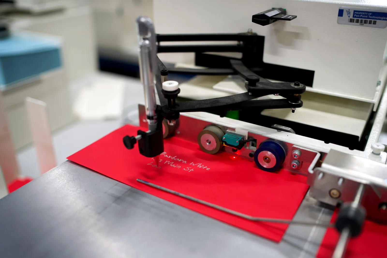 UniProd pen writing an address on a red envelope