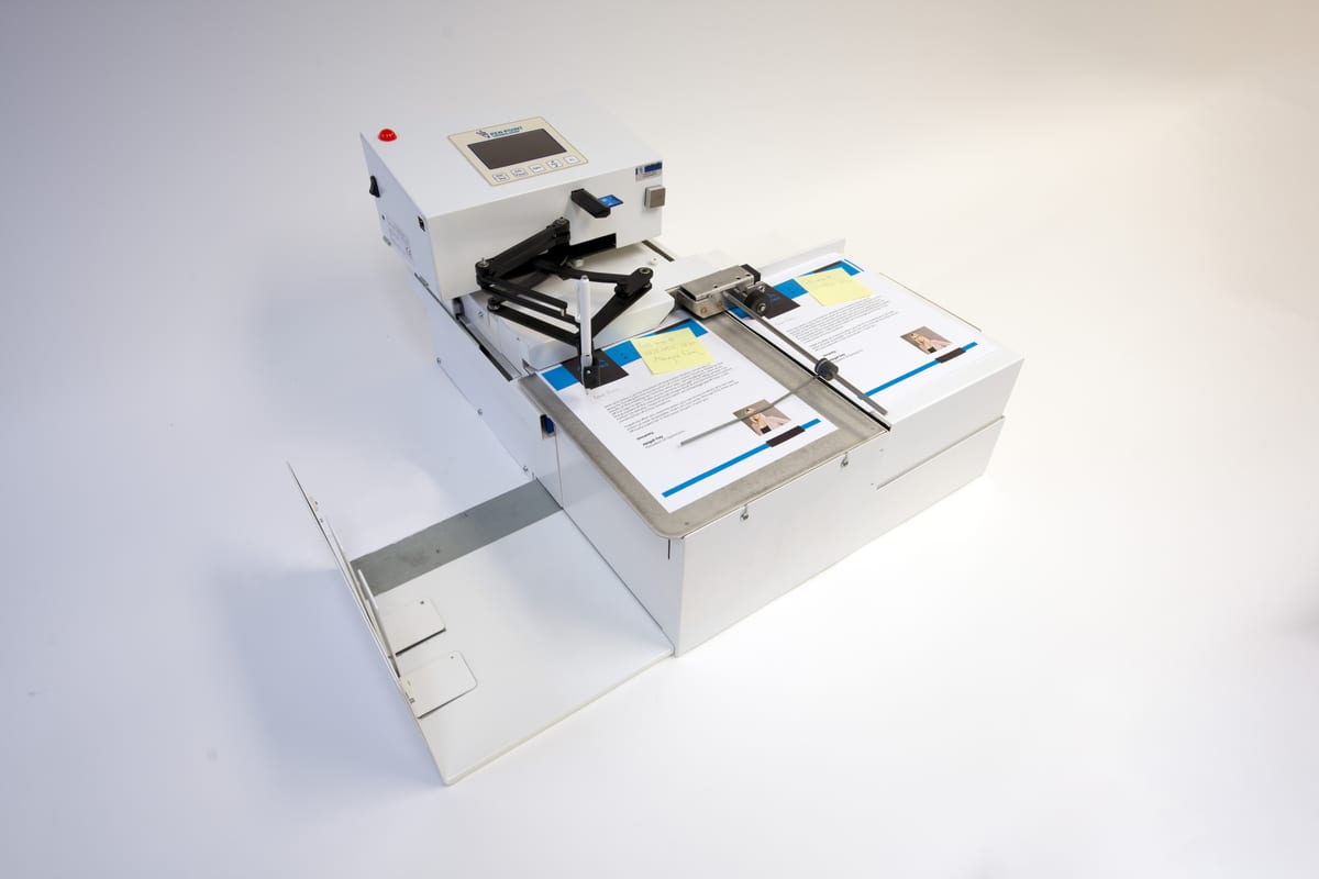 UniProd handwriting machine on a white backdrop with its catch tray extended